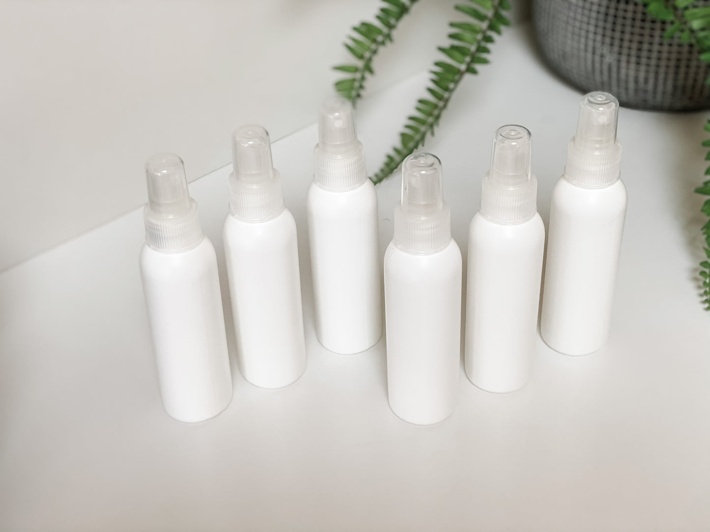 White Plastic HDPE 4 oz Bullet Round Bottles with White Fine Mist Sprayer - Homage Essentials & Co